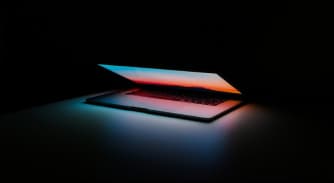Ordenador portátil iluminado sobre un fondo oscuro